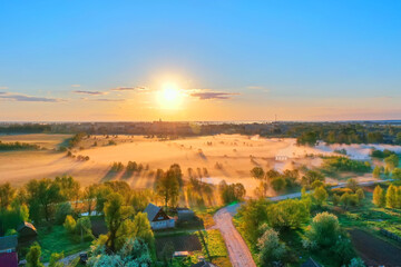 Aerial view height landscape sun above horizon, forest village with flying birds. Morning fog in the meadows mouth of the river during sunrise countryside.