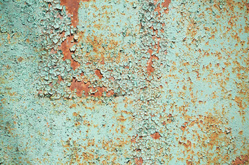old rusty garage wall with peeling green paint. high humidity spoils the paint on the metal. abandoned destroyed room