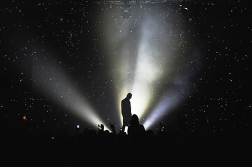 silhouette of a vocalist on stage and the effect of the starry sky. amazing show in the light of spotlights. concert for fans