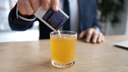 Crop close up of sick male employee pour dissolve powder have hot influenza tea in office, man...