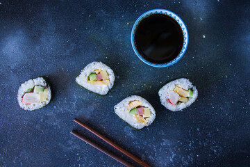 Kimbab or kimbap on the blue background with soy souse, blue background, studio shoot.