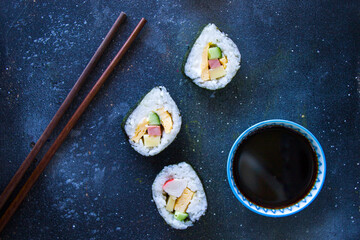 Kimbab or kimbap on the blue background with soy souse, blue background, studio shoot.