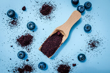 Dried blueberry powder on a wooden scoope