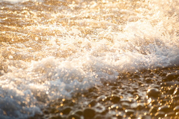 Blurred background with waves with spray in sunlight