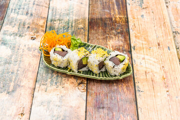 Ration of uramaki on wooden table