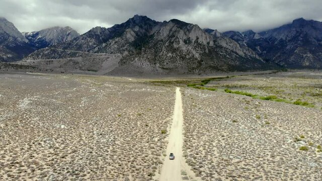 Aerial shot tracking a car driving away from Mount Whitney in the Sierra nevada mountain range in California USA