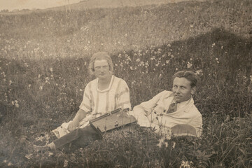 Germany - CIRCA 1920s: Married couple relaxing at field during picnic. Vintage Edwardian - Art deco...