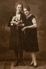 LATVIA - CIRCA 1930s Full body shot of two young women in studio Vintage Carte de Viste Edwardian era photo
