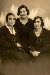 Germany - CIRCA 1930s: Portrait of three women sitting at bench in studio, Vintage Art Deco era photo
