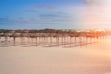 Fototapeta na wymiar Beach single umbrellas made of straw, empty beach .