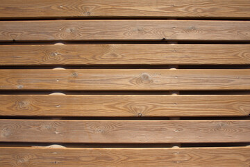 Background of brown wooden planks interspersed with beach sand.