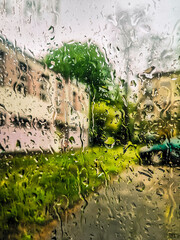 Waterdrops on the car window - blurred cityscape on the background
