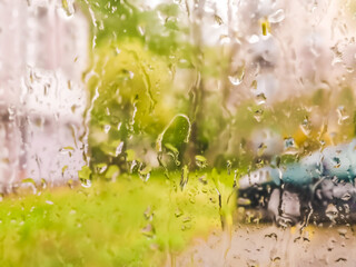 Waterdrops on the car window - blurred cityscape on the background
