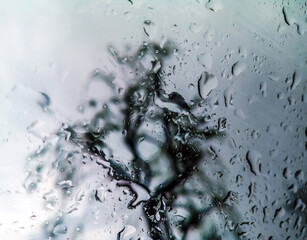 Waterdrops on the car window - blurred cityscape on the background