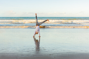 Masked young girl exercising on the beach with pirouettes