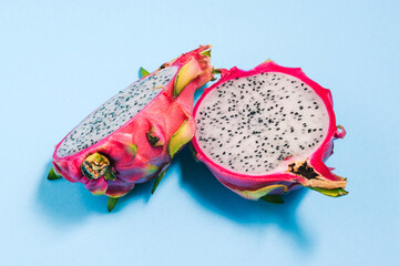 Cut pitaya on a blue background. Dragon fruit of the Hylocereus undatus species.