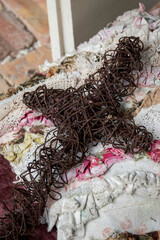 Rusty wire crucifix on a shabby chic quilt
