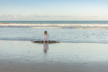 Child meditating on the beach exercises