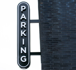a black and white parking sign for a parking garage on the wall of the parking garage notice  