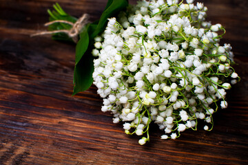 Delicate bouquet of lily of the valley on a wooden table. Bouquet for the holiday. Selective focus.