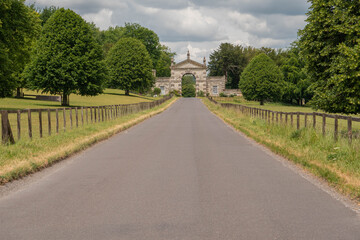 Fototapeta na wymiar Ground level view leading up the road to the gates of the Fonthill Estate in Wiltshire near Hindon
