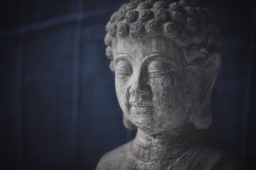 Fototapeta na wymiar Meditating Buddha Statue on dark background. Copy space.