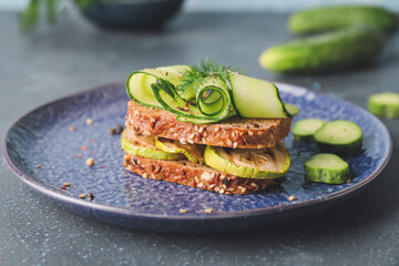 Plate with tasty cucumber sandwich on table