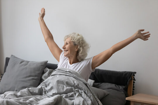 Active Elderly Woman Exercise Stretch In Comfortable Bed Awaken From Good Healthy Sleep At Home, Optimistic Mature Grandmother Wake Up In Bedroom, Welcome New Day Smiling, Happy Maturity Concept