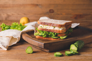 Tasty cucumber sandwich on table