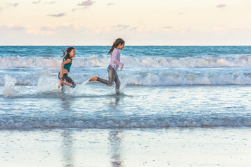 Children running on the beach juggling joy