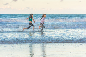 Children running on the beach juggling joy