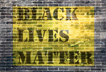 Black Lives Matter slogan protestors anti Black racism african American yellow stencil patternbrick of dark stone texture