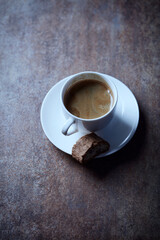 Cup of coffee with cantuccini (Italian biscuits) on rustic stone background.