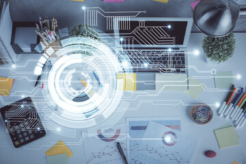 Double exposure of data drawing hologram over topview of study desk background with computer....