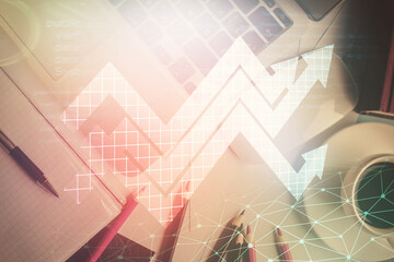 Arrows hologram drawings over computer on the desktop background. Top view. Double exposure. Concept of growth.