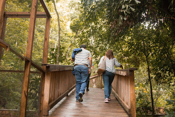 adult couple crossing a wooden bridge in the forest