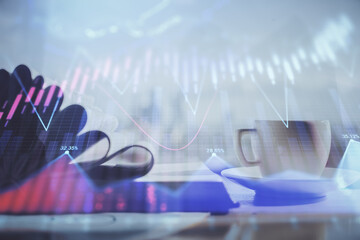 Double exposure of financial chart drawing and desktop with coffee and items on table background....