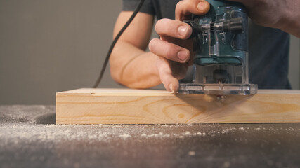 Woodworker cut chamfer at wood. Milling cutter and sawdust, closeup. Professional carpentry concept with copy space.