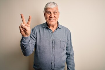 Senior handsome hoary man wearing casual shirt standing over isolated white background showing and pointing up with fingers number two while smiling confident and happy.