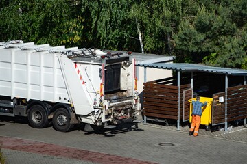 Garbage truck and workers collecting garbage.