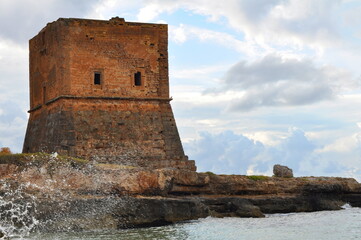 Old tower on the coast next to the beach.