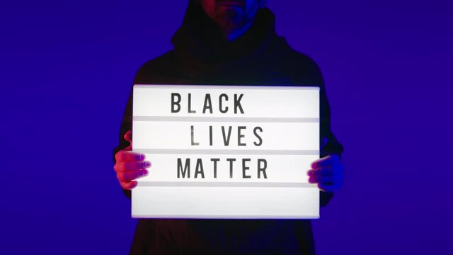 White young man holds motivational political sign - black lives matter. Send powerful new normal politics and social quote or message in regards of current racist events. Revolutionary and protest 