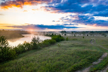 Beautiful morning sunrise on the river. Quiet landscape with fog in the background of the forest