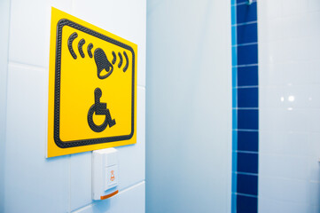 Yellow plate with the image of a disabled person and a call button