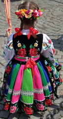 the girl in a traditional folk dress from Lowicz in Poland, while joins Corpus Christi procession...