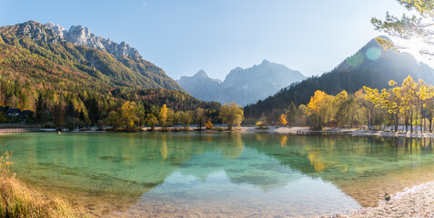 Calm evening with mirror reflections at Lake Jasna with Triglav mountains in the background in...
