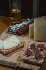 Queso manchego, chorizo. fuet, embutidos Españoles, tabla de madera, aceite, típica Spanish, pan con tomate