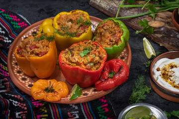 Vegetarian rice stuffed peppers along with side dishes in a traditional Mexican setting