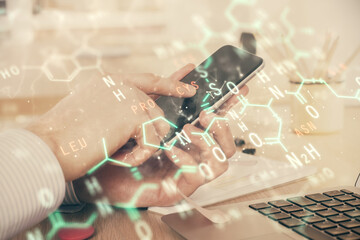 Double exposure of man's hands holding and using a phone and formulas drawing. Education concept.