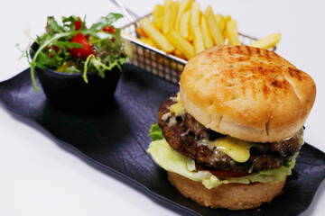 cheese melted barbecued beef burger with bowl of salad and french fries